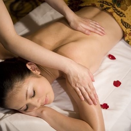 Woman getting a massage with rose pedals